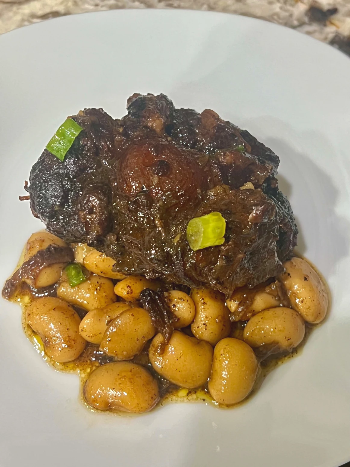 Jamaican oxtail and butter beans plated in rich gravy